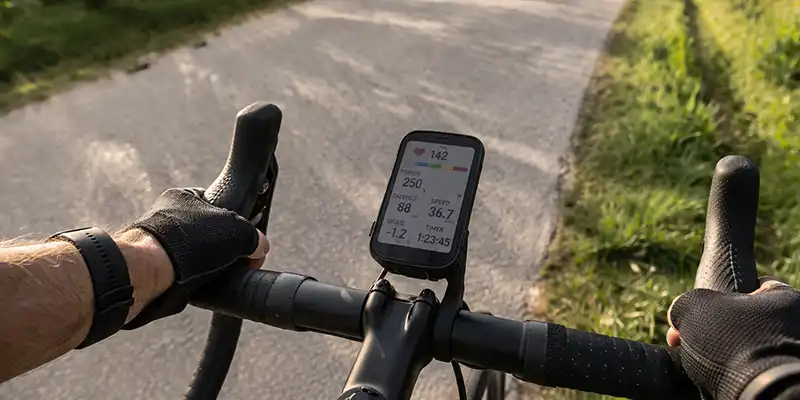 Cykelcomputer med datafelter for puls, fart og watt under aktiv tur.