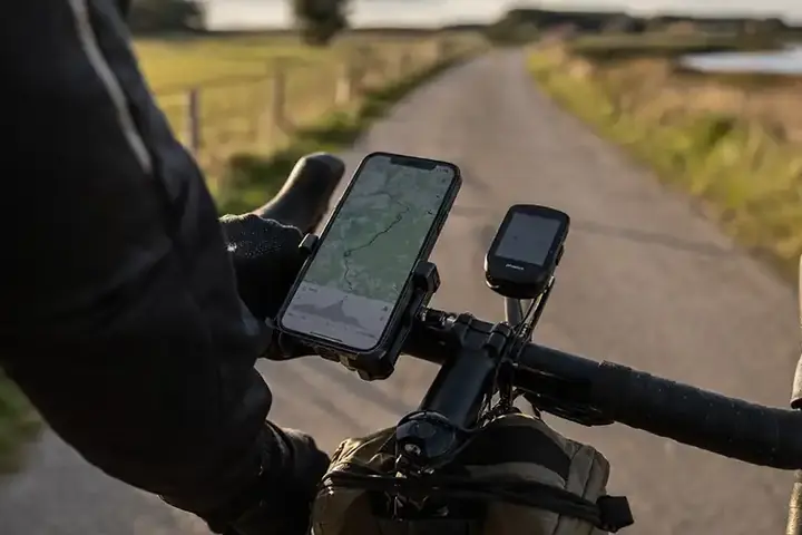 Telefon og cykelcomputer på styret under en dansk cykeltur med fokus på data og tracking.