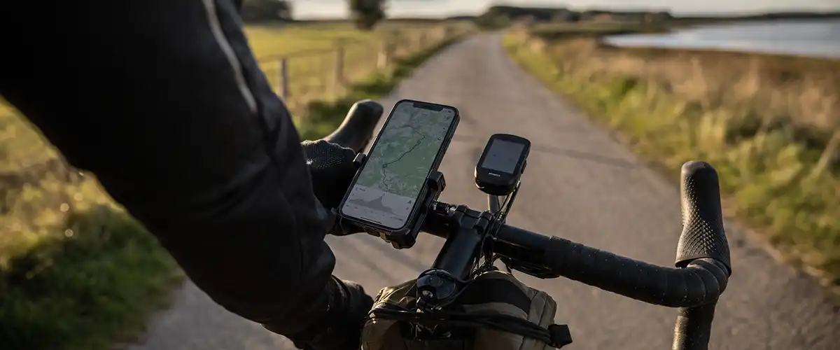 Telefon og cykelcomputer på styret under en dansk cykeltur med fokus på data og tracking.