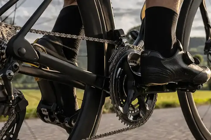 Nærbillede af cykelgear og kæde under aktiv kørsel med fokus på teknik og belastning.