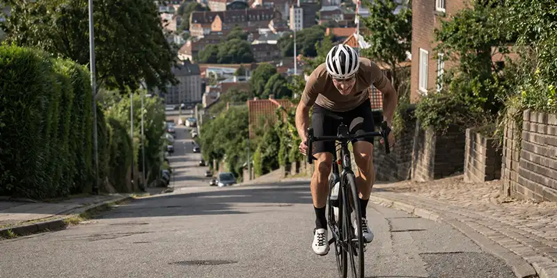 Rytter på vej op ad Marselisborg-bakke med byudsigt og tungere tråd.