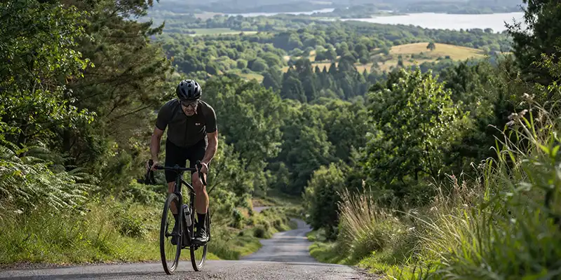 Rytter i kuperet terræn ved Rebild Bakker med højere belastning og åbent udsyn.