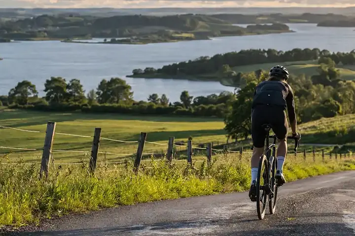 Cyklist i Himmerlands kuperede landskab med skovkant, bakker og længere dansk naturtur.