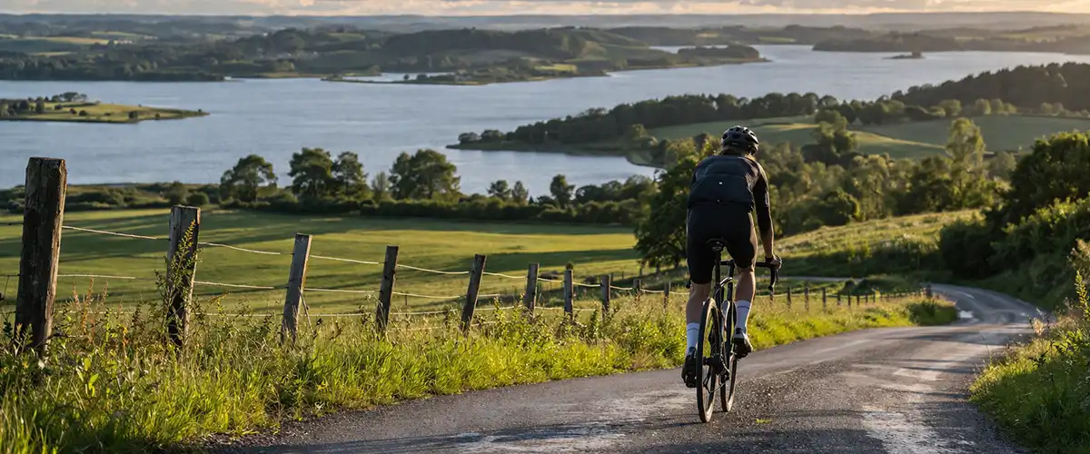 Cyklist i Himmerlands kuperede landskab med skovkant, bakker og længere dansk naturtur.