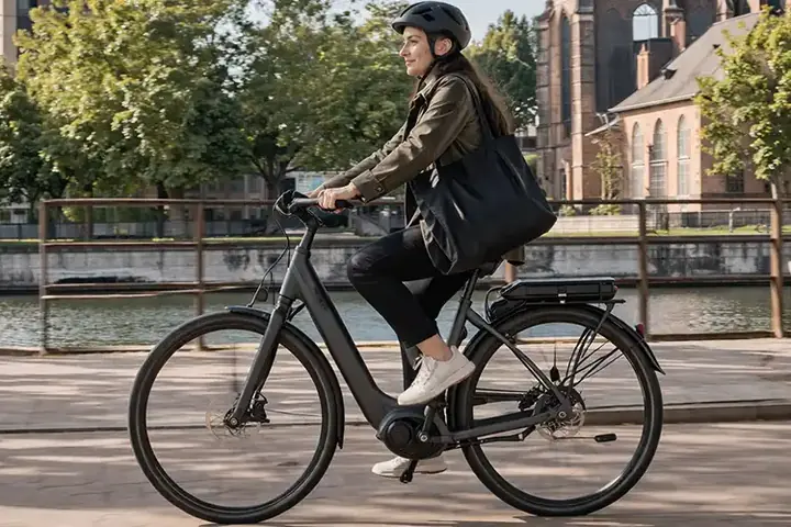 Elcyklist i dansk bymiljø med let assistance, åben cykelsti og pendlerpræg.