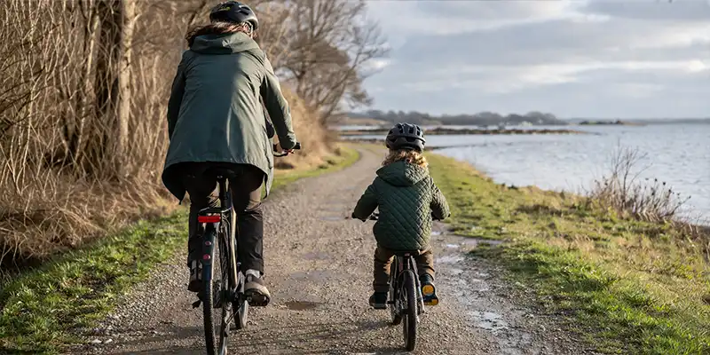 Barn og voksen på rolig cykeltur med lav fart og mange små stop.
