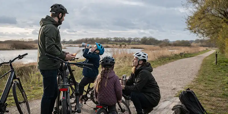 Familie på 15 km rute med pauser og sikkerhedsfokus i bynært grønt område.