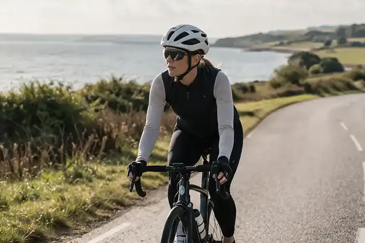 Rolig motionscyklist på dansk landevej i stabil rytme med fokus på udholdenhed og jævnt tempo.