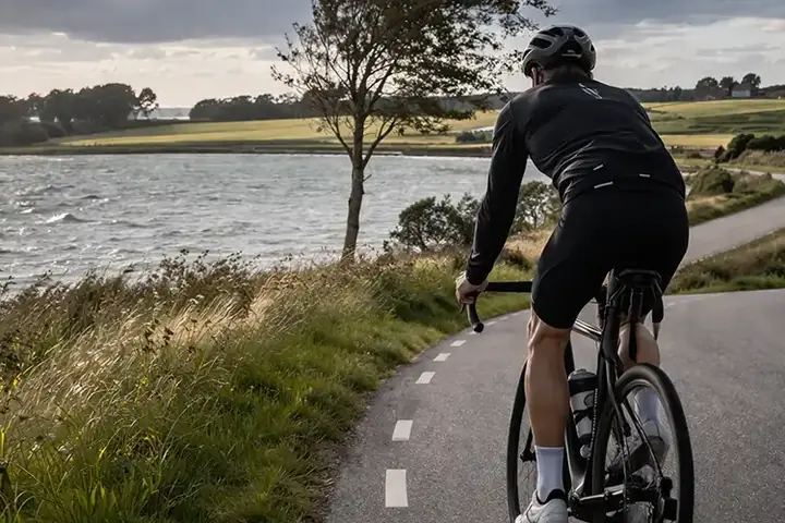 Cyklist på åben fynsk landevej med marker, sidevind og en lang tur over øen.