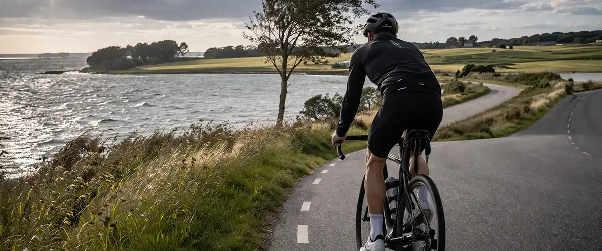 Cyklist på åben fynsk landevej med marker, sidevind og en lang tur over øen.