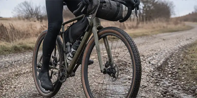 Gravelcykel med bredere dæk på ujævnt underlag og mere rulmodstand.
