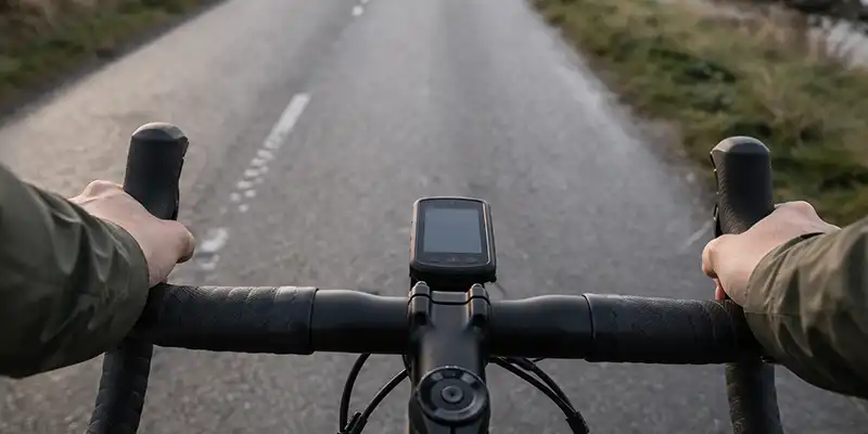 Rytter med cykelcomputer, drikkedunk og stabilt tempo på dansk landevej.