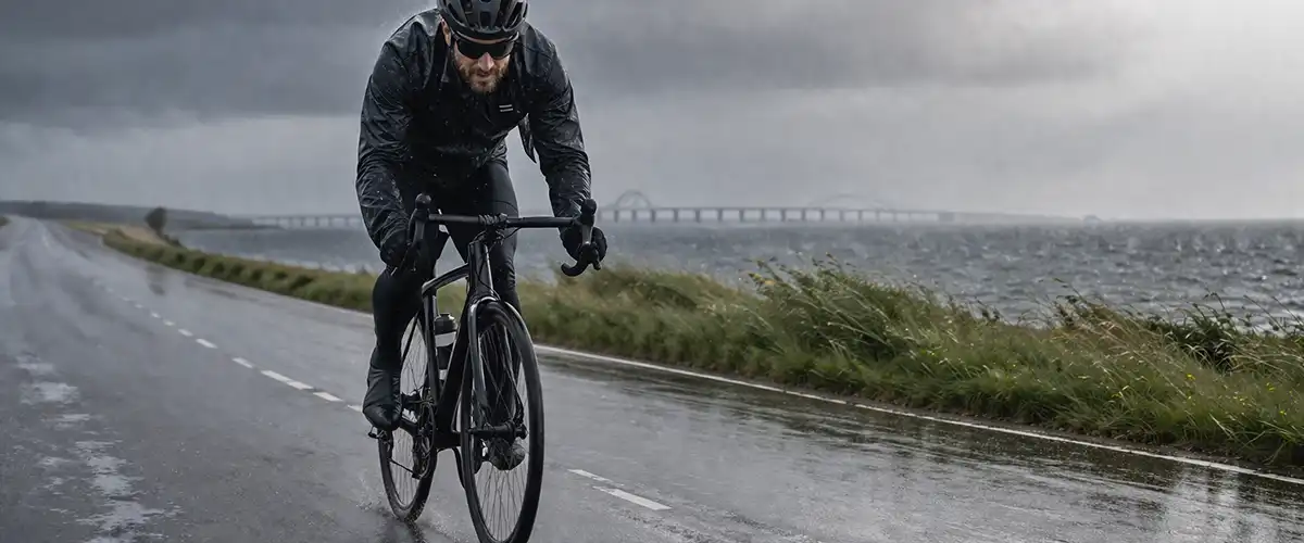 Cykling i regn og køligt vejr med lag-på-lag tøj og våde veje.